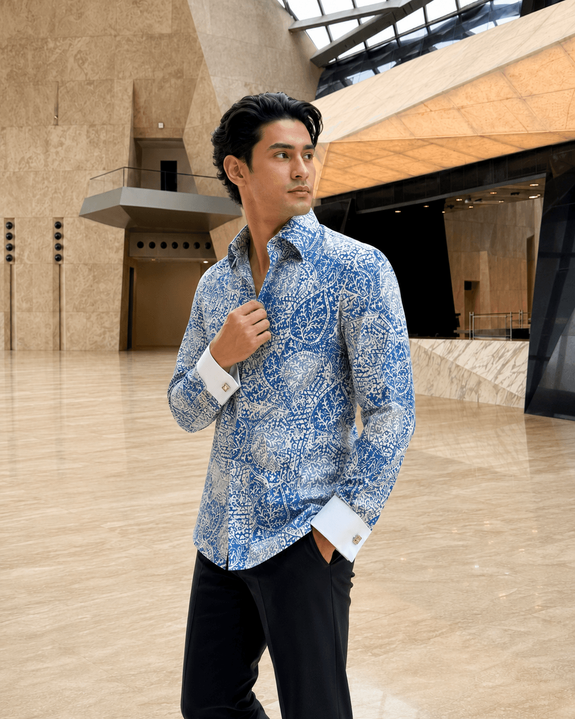 Concept image of a man in a blue-and-white patterned batik shirt with white French cuffs and an open collar.